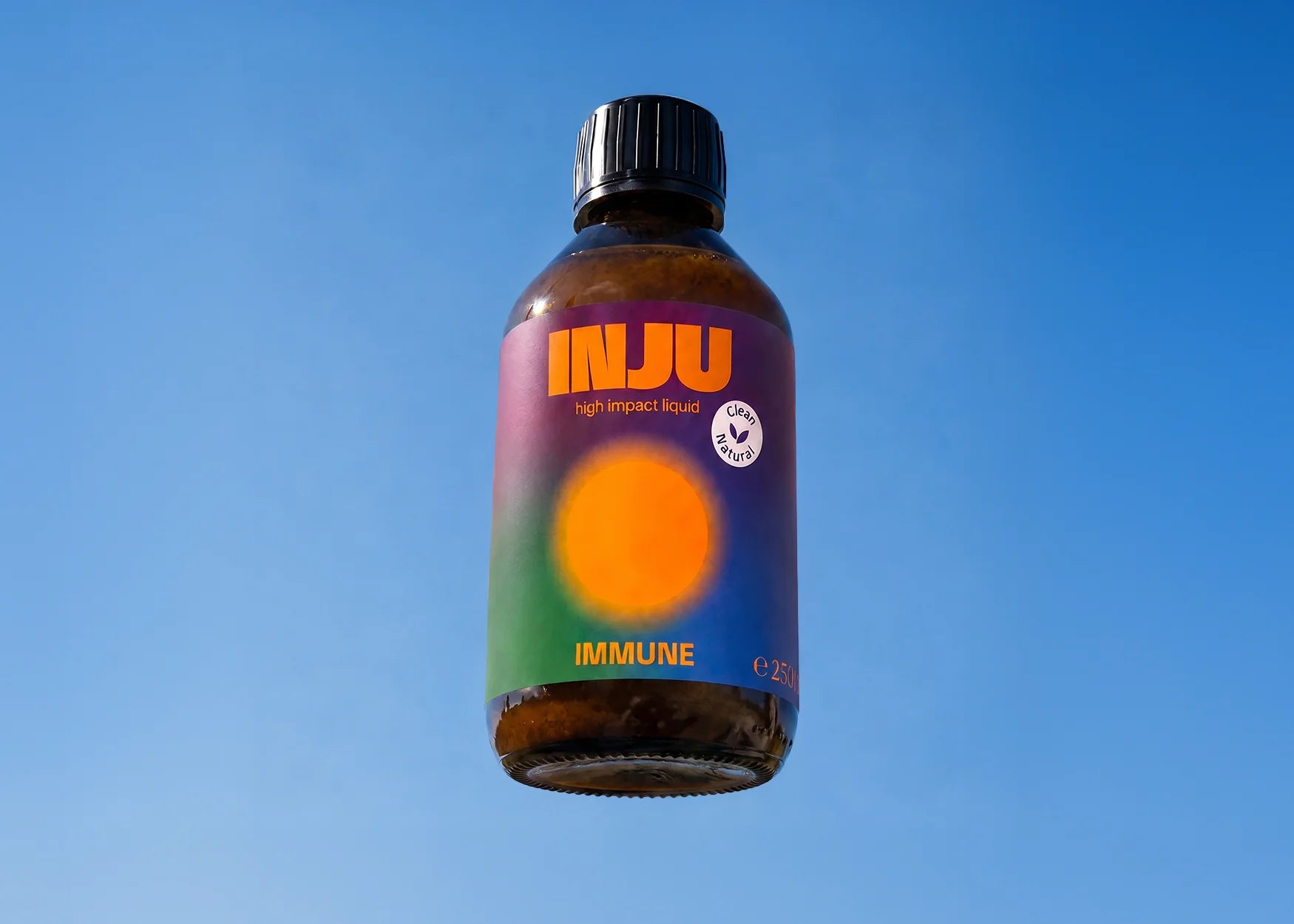INJU IMMUNE-Braunglasflasche vor blauem Himmel. Das grün-violette Etikett zeigt das Logo und einen leuchtend orangefarbenen Kreis.