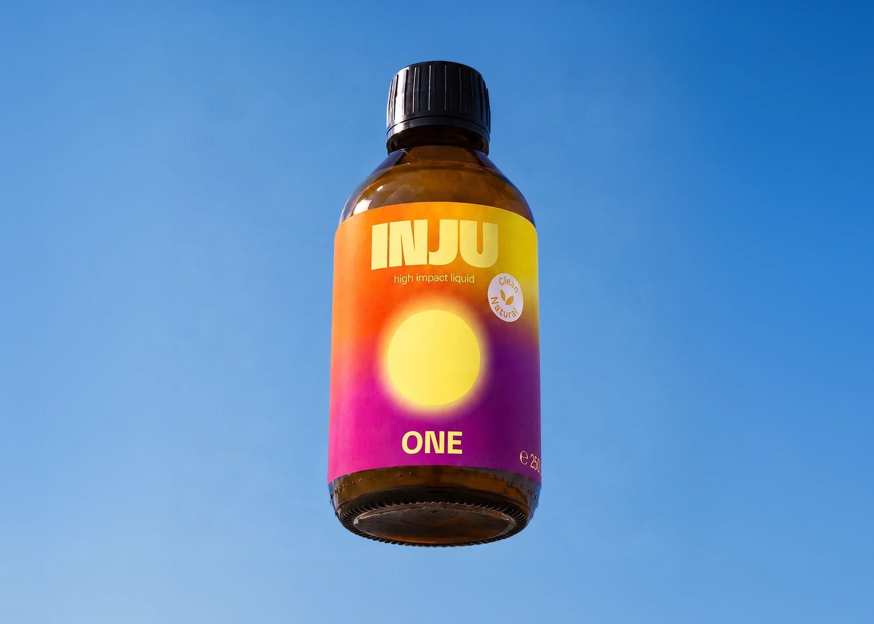 INJU ONE-Braunglasflasche vor blauem Himmel. Das orange-violette Etikett zeigt das Logo und einen leuchtend gelben Kreis.