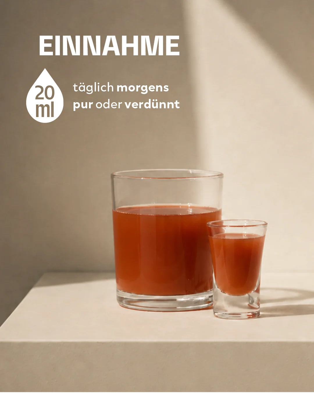 Ein Wasserglas und ein Shotglas gefüllt mit der rötlich-orangen INJU Pro-Age Flüssigkeit auf beigem Grund. Text-Info: 20 ml täglich morgens pur oder verdünnt einnehmen.