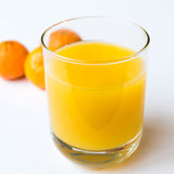 Ein Glas Orangensaft und drei Orangen