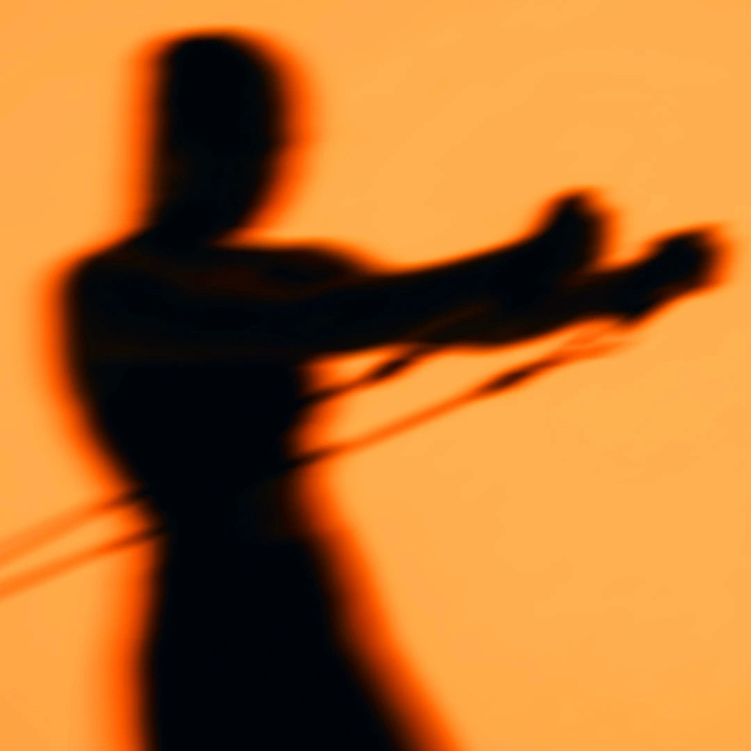 Dynamische, stark verschwommene Silhouette einer Person vor einem warmen, orangefarbenen Hintergrund, die mit beiden Händen an einem Fitness-Widerstandsband zieht.