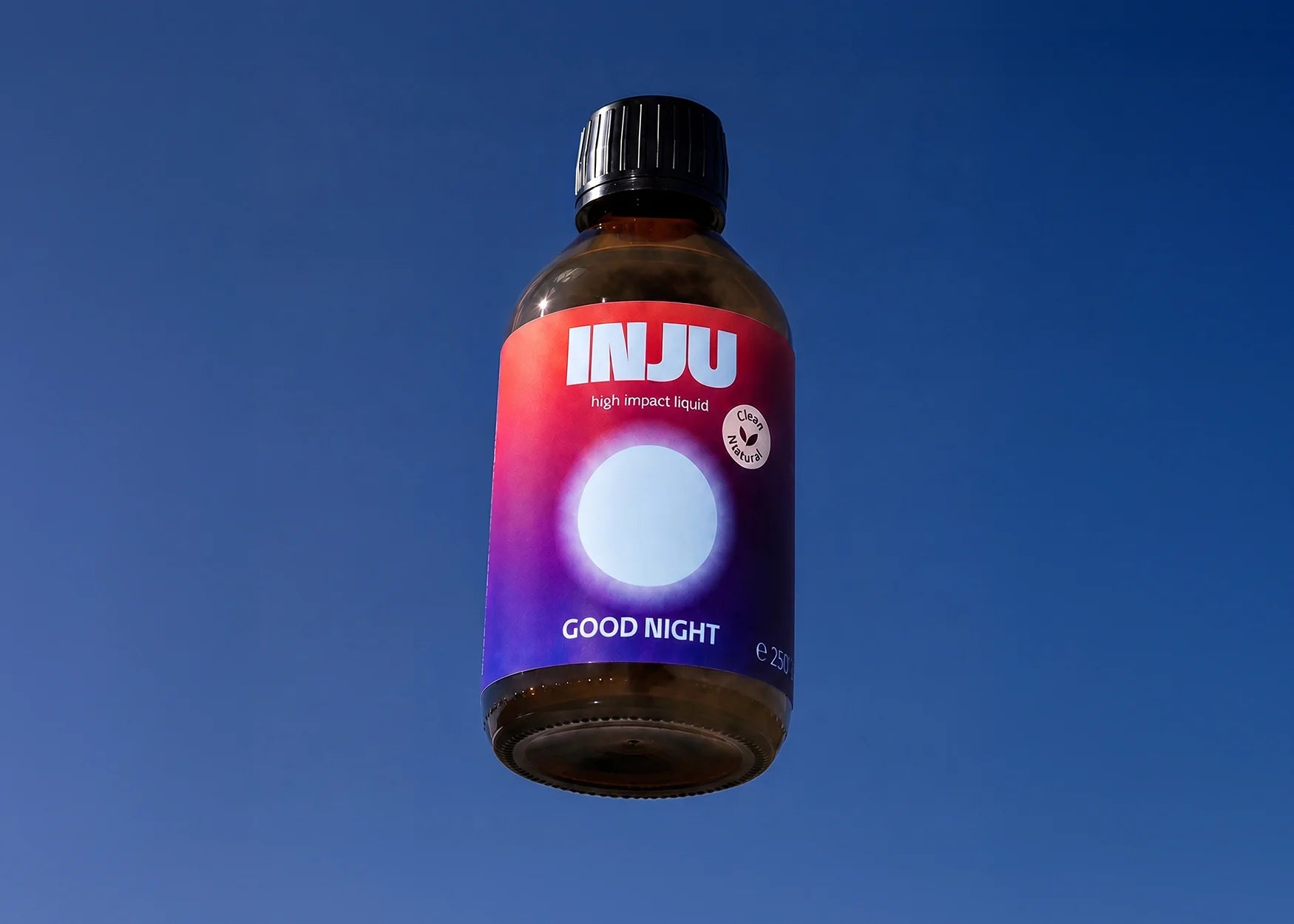 INJU GOOD NIGHT Glasflasche vor blauem Himmel. Das violett-blaue Etikett zeigt das Logo und einen sanft hellblau leuchtenden Kreis.