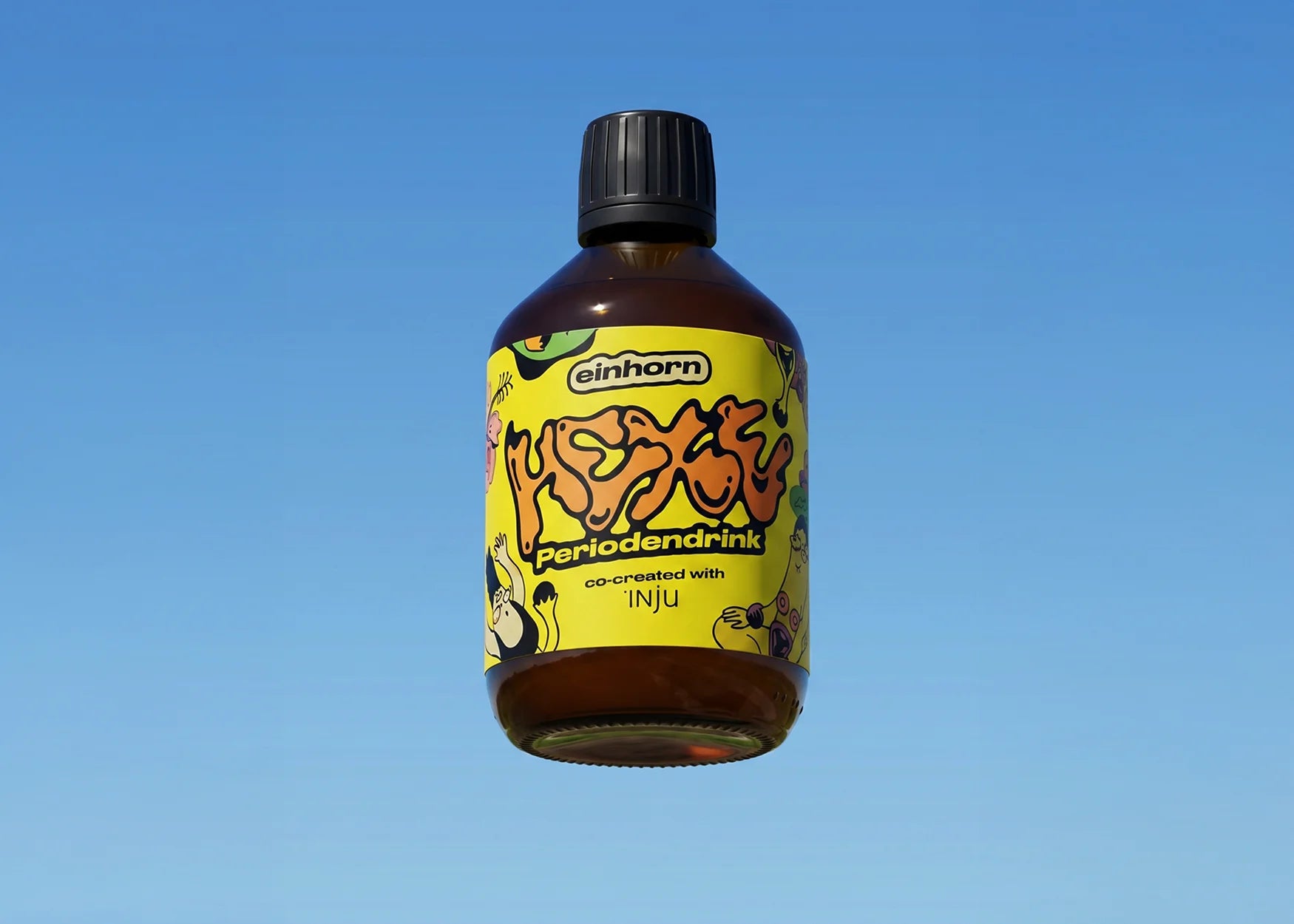 einhorn HEXE Periodendrink-Braunglasflasche vor blauem Himmel. Das gelbe Etikett zeigt einen Comic-Schriftzug und bunte Illustrationen.