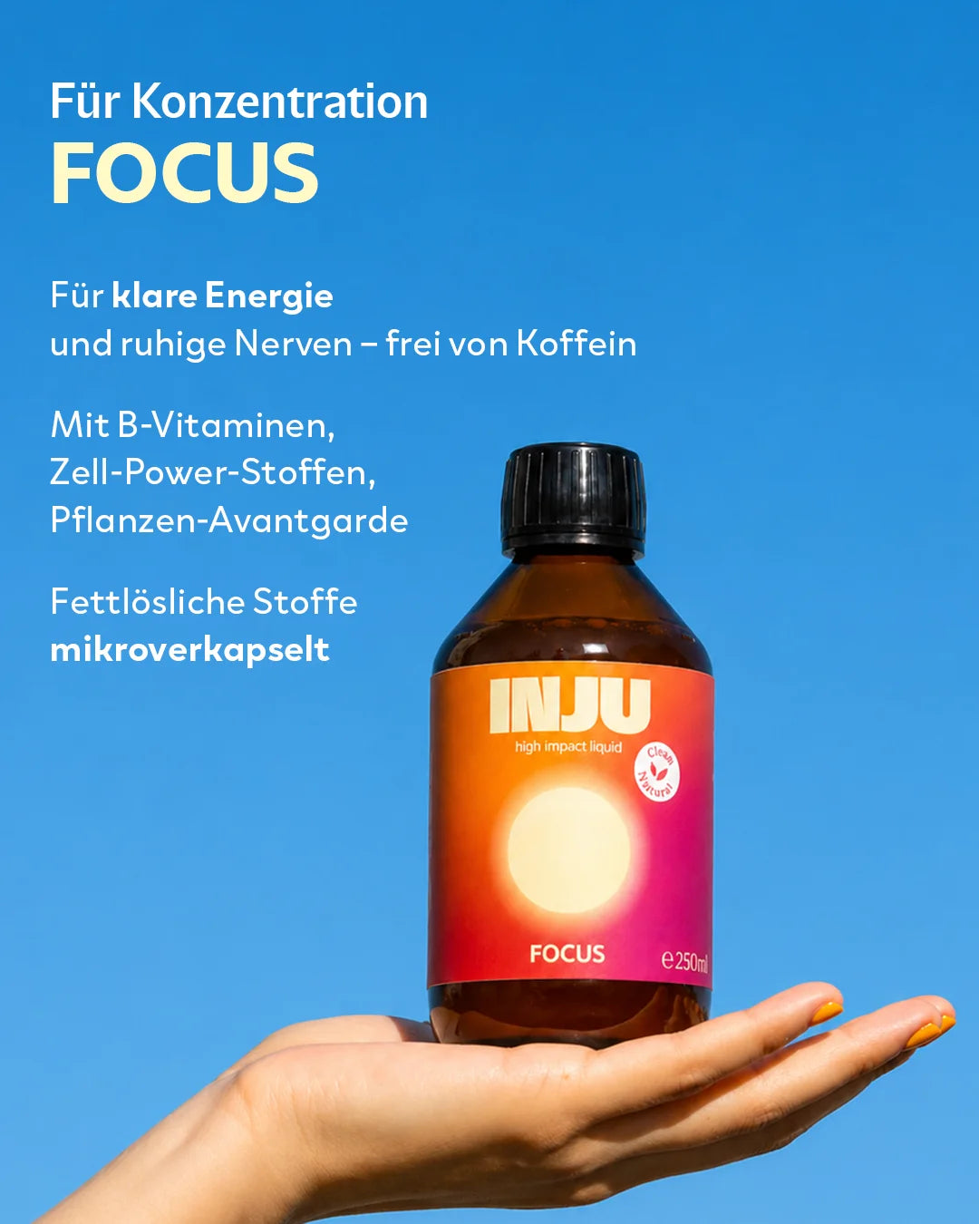 Eine Hand hält die INJU Focus Flasche mit leuchtendem orange-pinkem Etikett vor blauem Himmel. Der Text bewirbt klare Energie, Fokus und ruhige Nerven ohne Koffein durch mikroverkapselte B-Vitamine und Zell-Power-Stoffe.